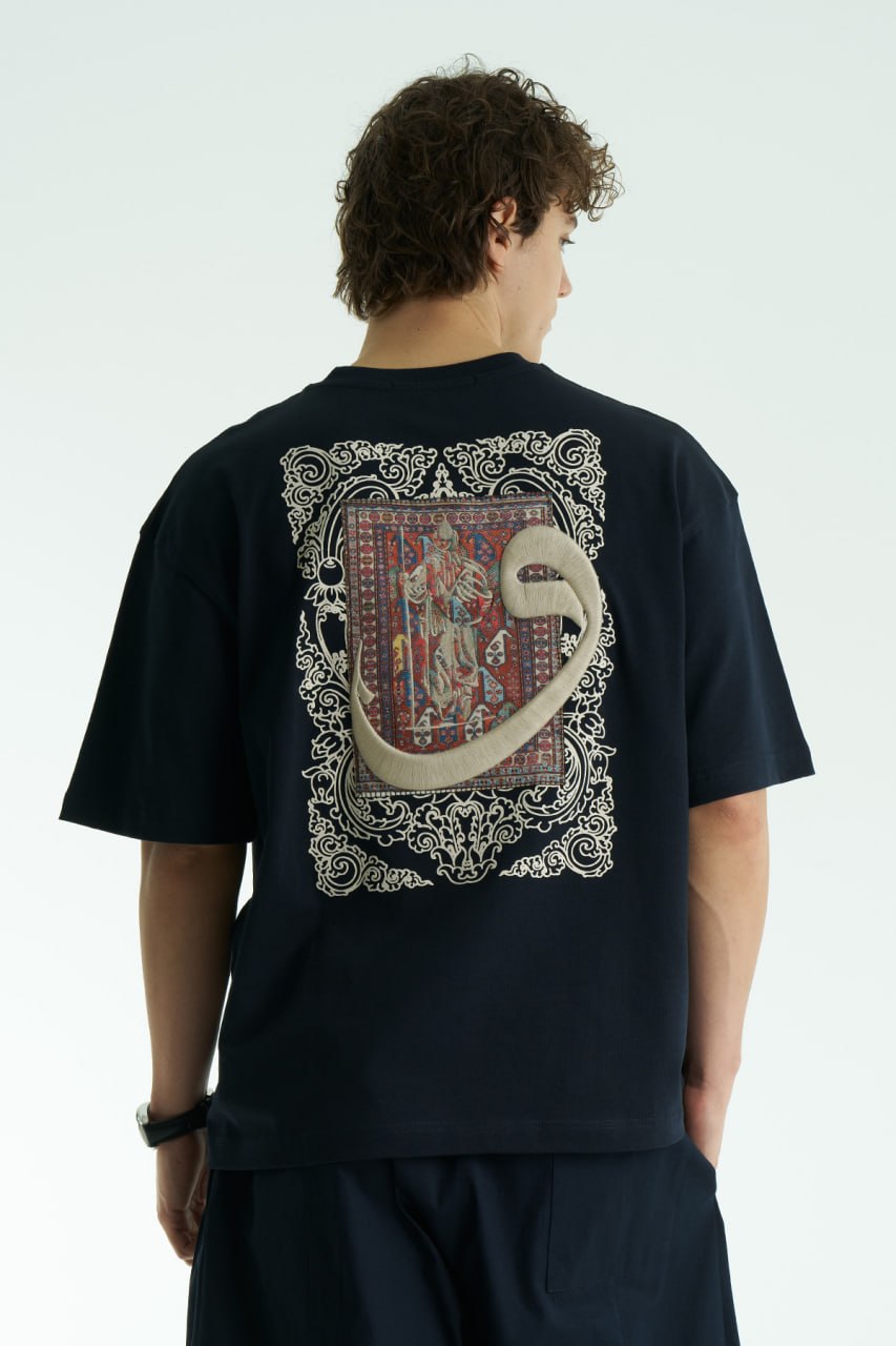 Navy Oversized cotton graphic T-shirt with small chest emblem and large ornate framed back print, shown in black, white, brown, and navy.