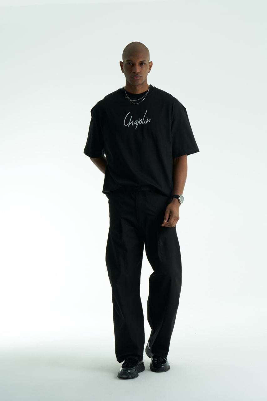 Black Chaplin oversized cotton graphic T-shirt with front script logo and collage patch back, shown in black and white