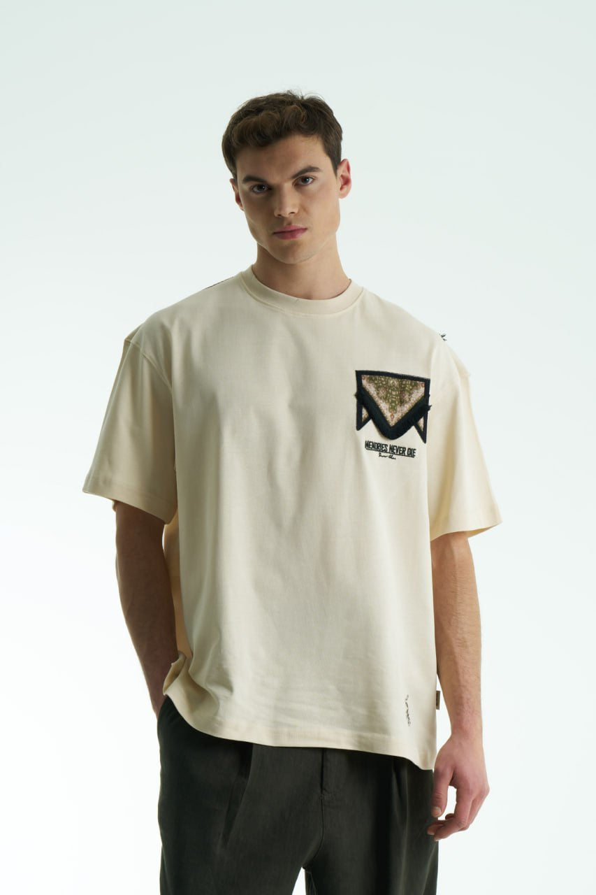 Beige Oversized Memories Never Die cotton tee with chest pocket appliqué and scarf-style back yoke, shown in white, beige, and black.