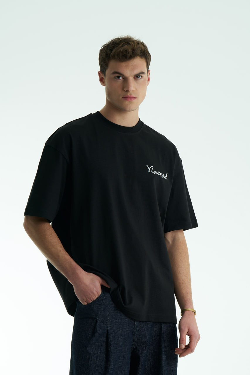 Black Vincent oversized crewneck graphic T-shirt with small chest logo and large illustrated back print, shown in black, white and cream.