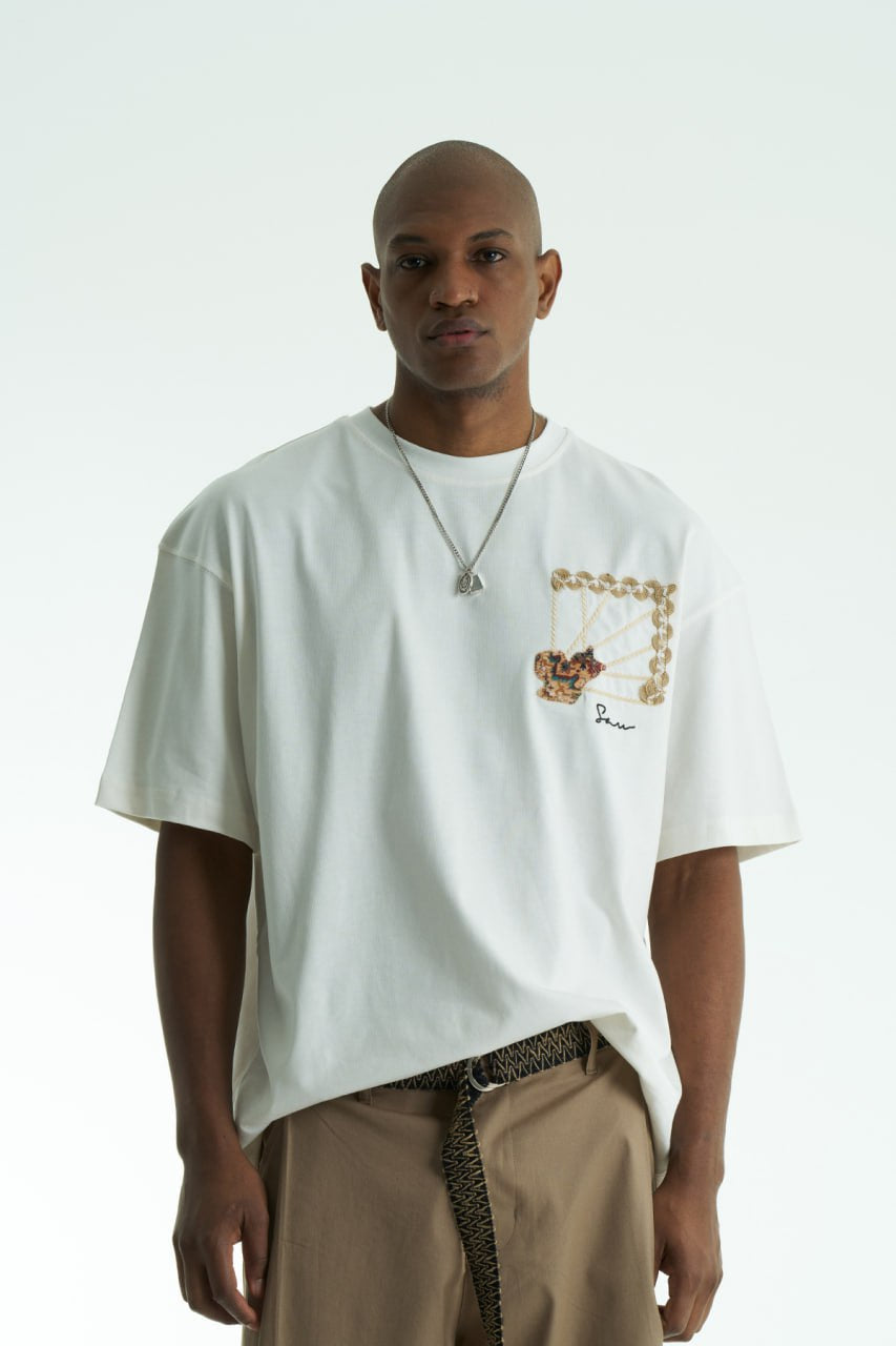 White Senu oversized crewneck graphic T-shirt with rope-frame tapestry emblem, shown in black, white, brown and navy with front and back views