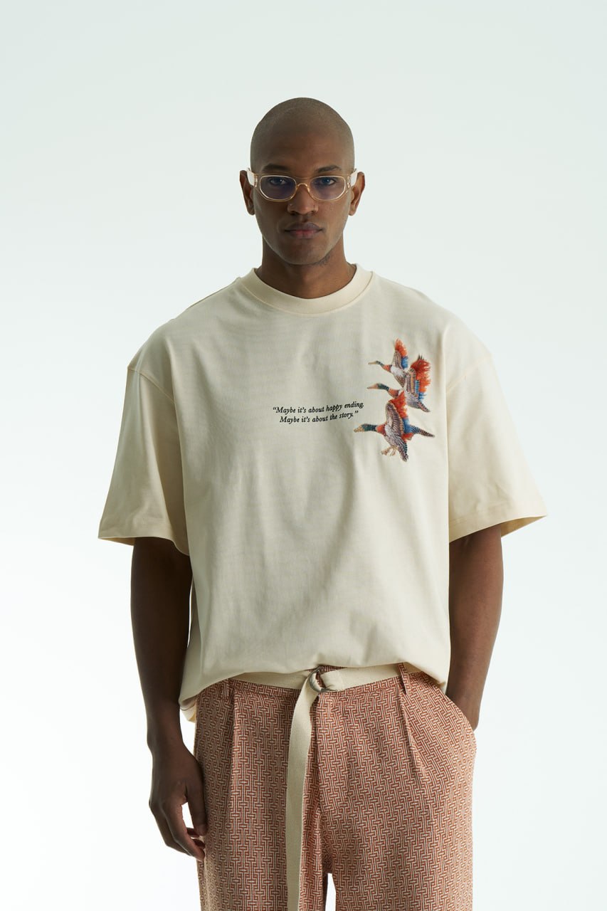 Beige Oversized cotton T-shirt with embroidered flying ducks and quote print, shown in multiple colorways front and back.