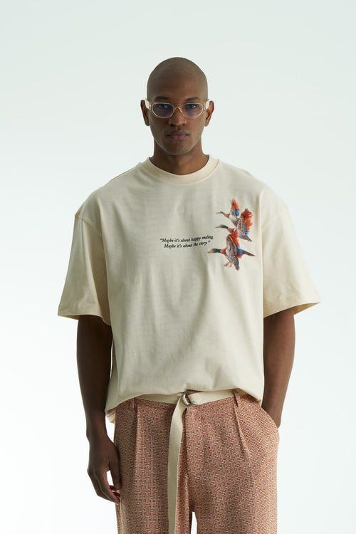 Beige Oversized cotton T-shirt with embroidered flying ducks and quote print, shown in multiple colorways front and back.