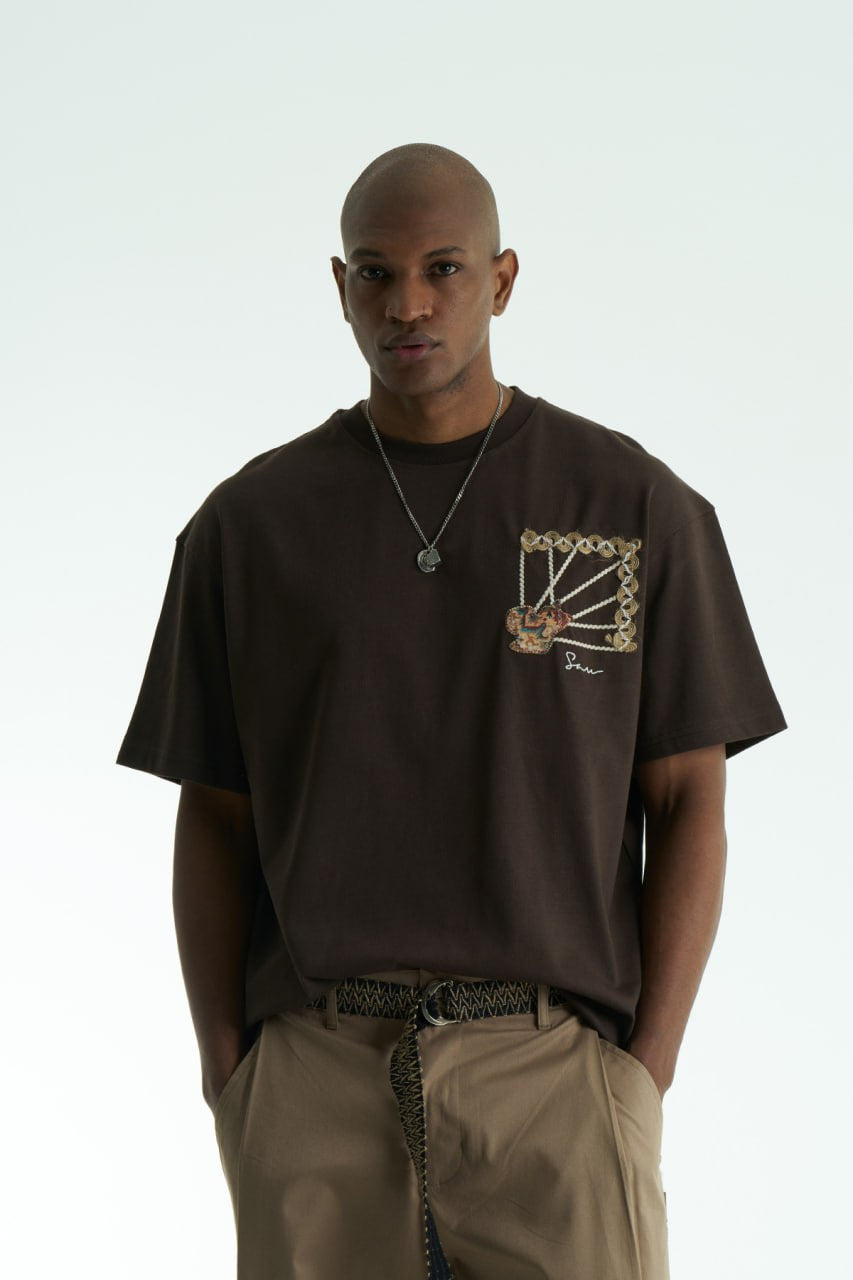 Brown Senu oversized crewneck graphic T-shirt with rope-frame tapestry emblem, shown in black, white, brown and navy with front and back views