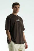 Dark Brown Oversized cotton graphic T-shirt with minimalist chest logo and stitched back artwork patch, shown in multiple colorways on model