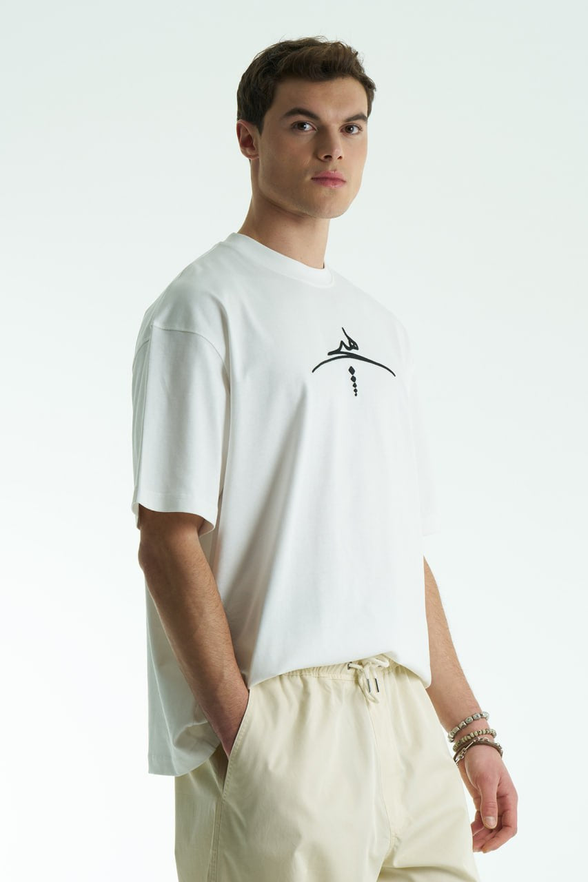 White Oversized cotton graphic T-shirt with minimalist chest logo and stitched back artwork patch, shown in multiple colorways on model