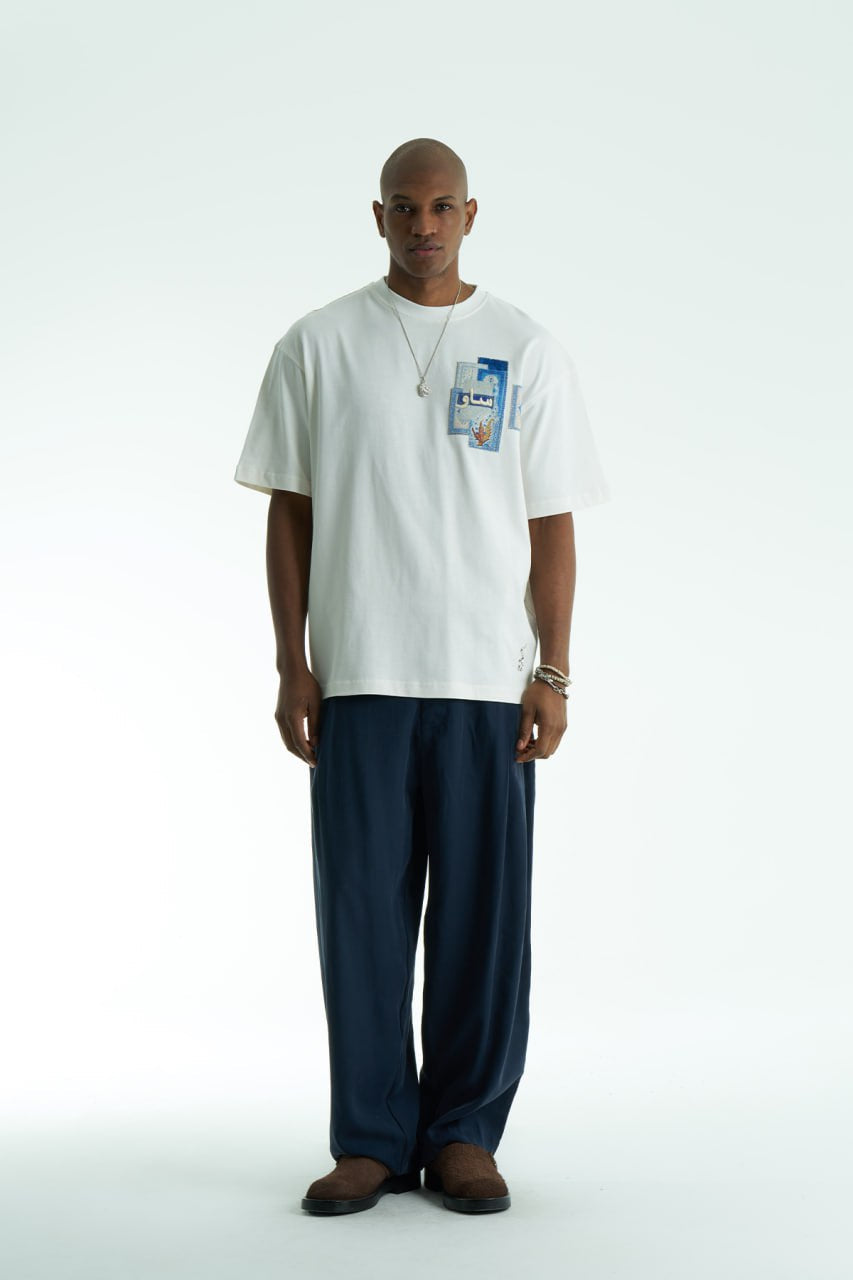 White Oversized SAVO graphic cotton T-shirt with small chest print and large blue tile-collage back print, shown in multiple colors
