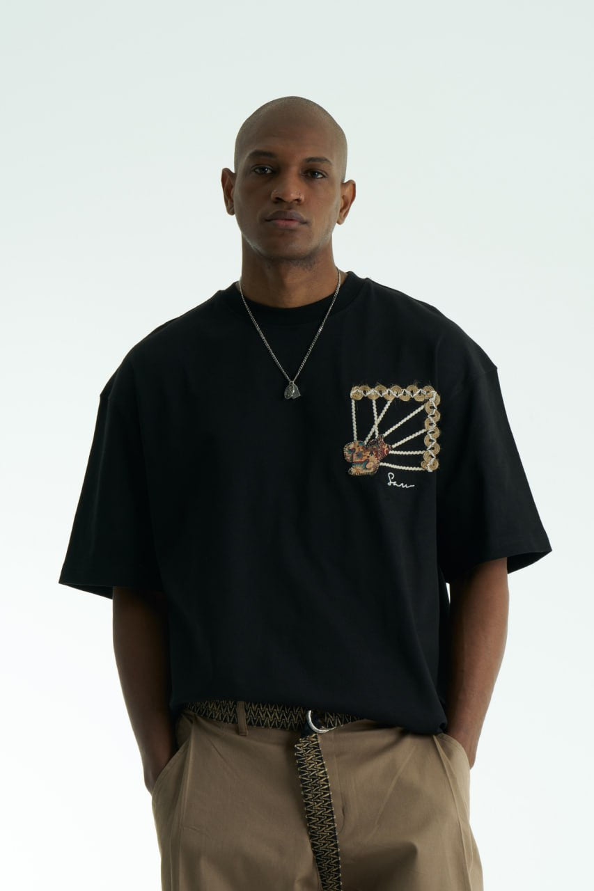 Black Senu oversized crewneck graphic T-shirt with rope-frame tapestry emblem, shown in black, white, brown and navy with front and back views
