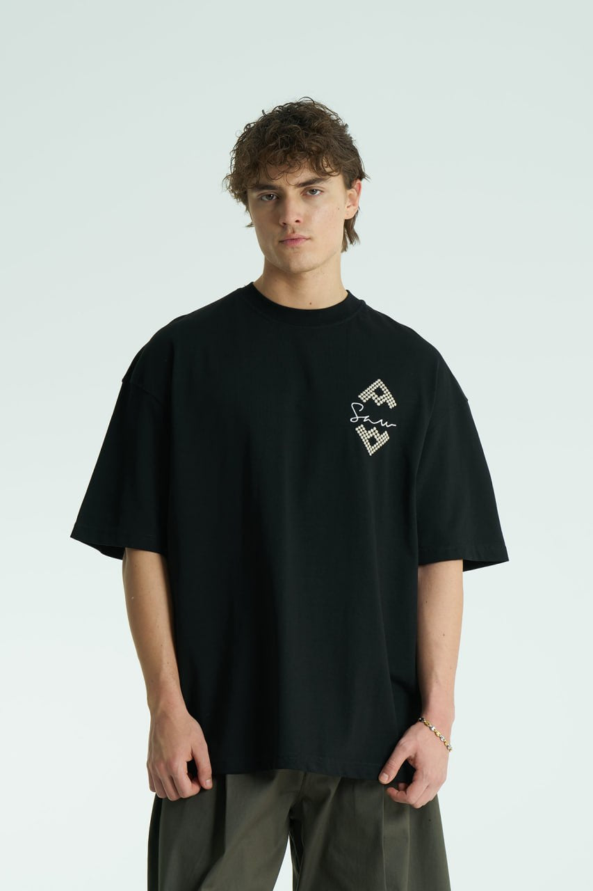 Black Oversized Sam graphic T-shirt with ornate back print and rhinestone-style detailing, shown in white, black, brown and navy