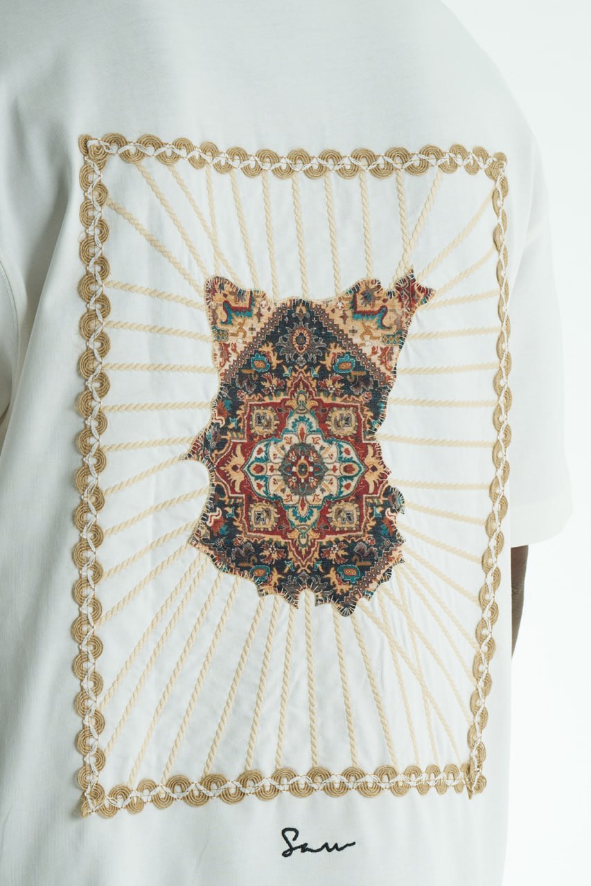 White Senu oversized crewneck graphic T-shirt with rope-frame tapestry emblem, shown in black, white, brown and navy with front and back views