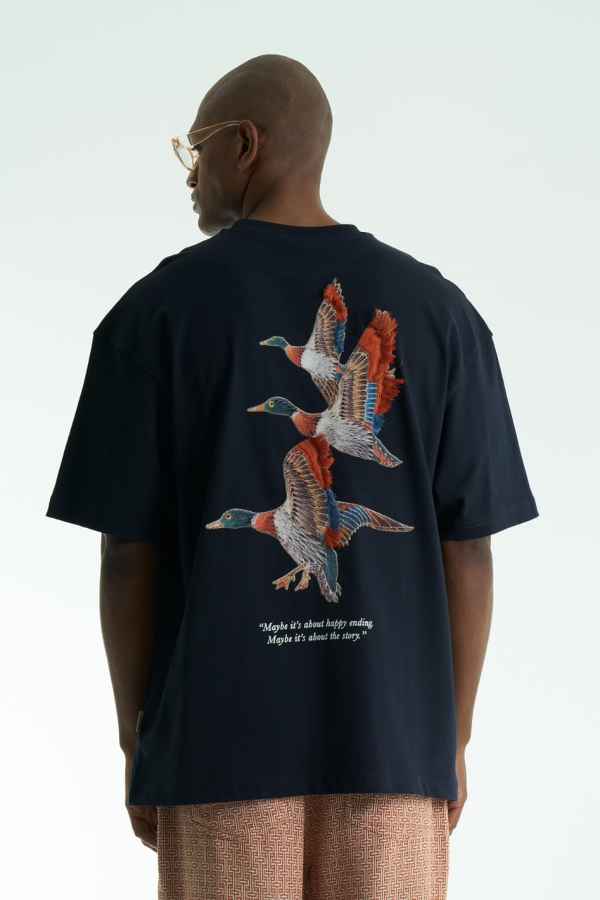 Navy Oversized cotton T-shirt with embroidered flying ducks and quote print, shown in multiple colorways front and back.