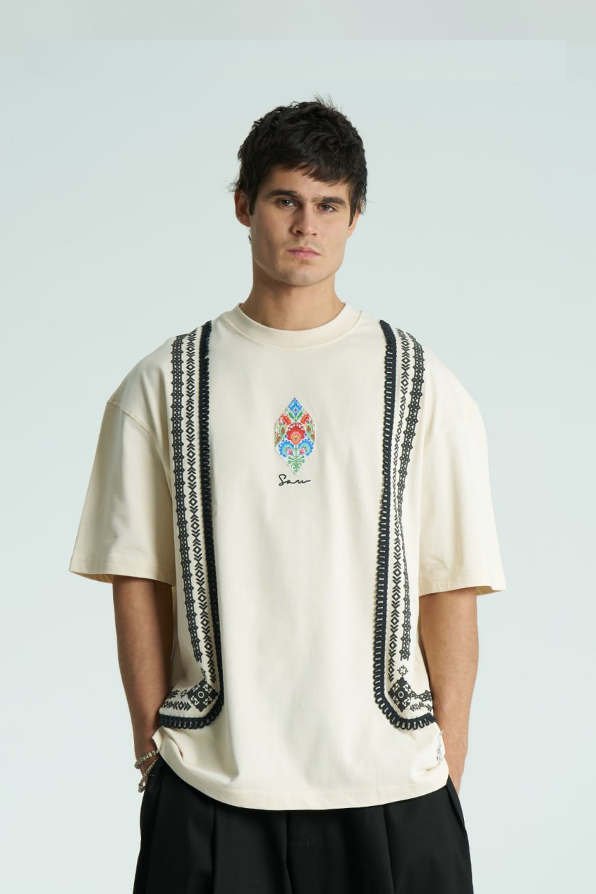 Cream Sam oversized crewneck graphic T-shirt with embroidered motif and ornate border trims in black, cream, and white colorways
