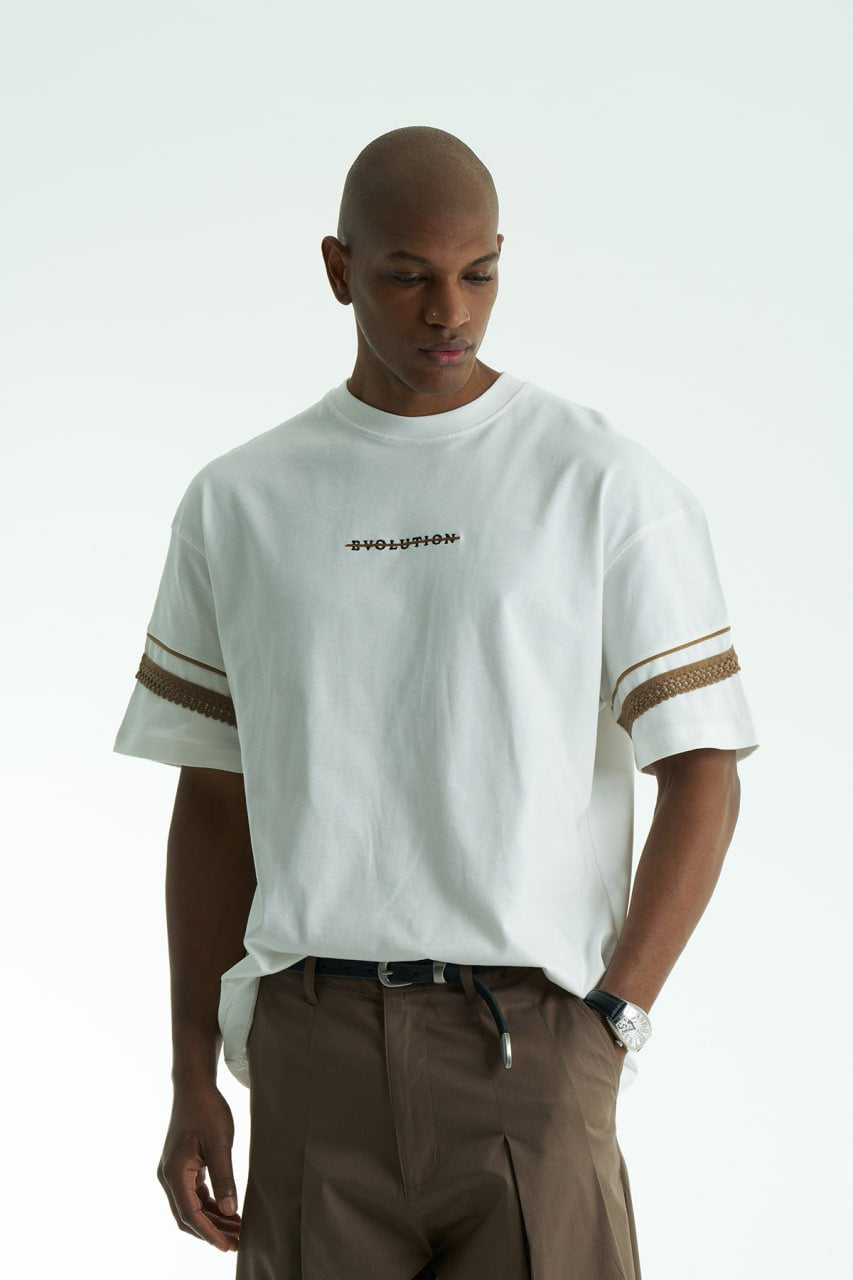 White Evolution oversized crewneck graphic T-shirt with sleeve trim and ornate back print in black, white, navy, and cream